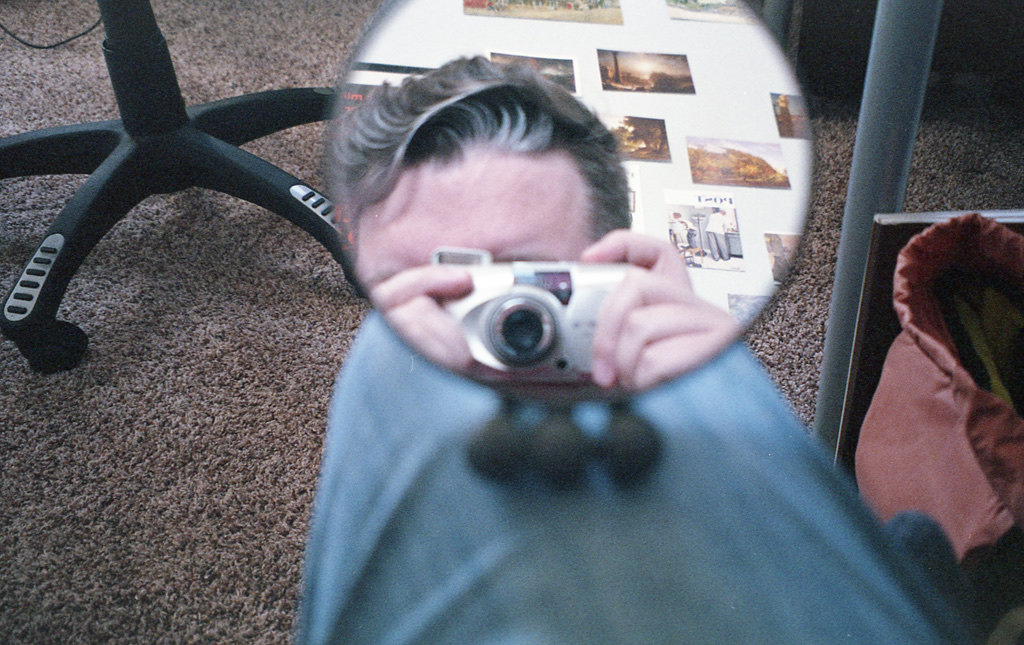 Polaroid of Ponders on a pier with camera, ready to take a picture off the right side of the frame.